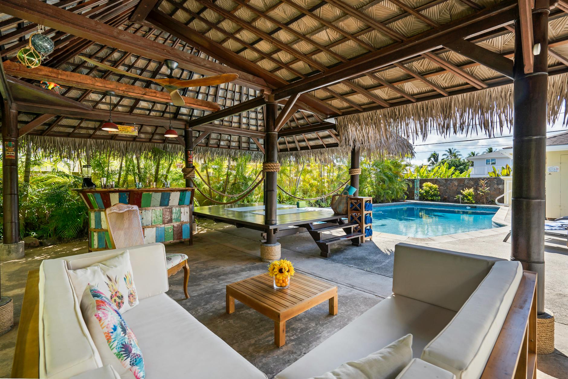 Tropical outdoor patio featuring a cabana seating area and swimming pool for luxury relaxation